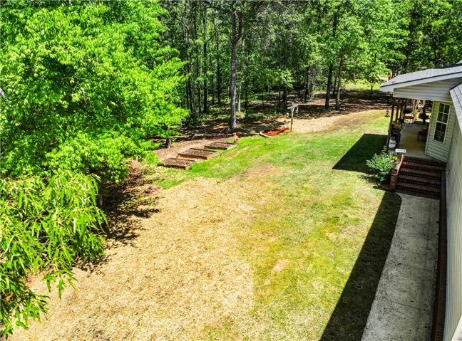 This verdant yard features a charming patio and natural surroundings.