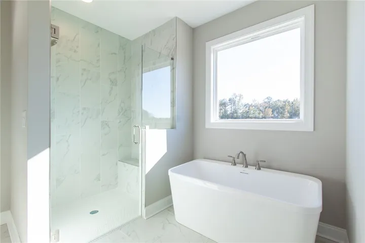 This bright bathroom offers a tranquil retreat with a spacious walk-in shower and inviting soaking tub.