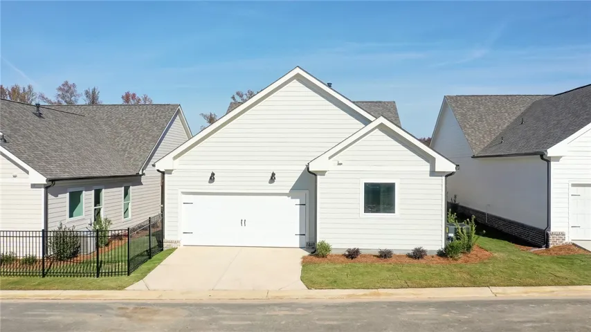 This newly constructed residence offers a clean facade with an attached garage and simple landscaping.