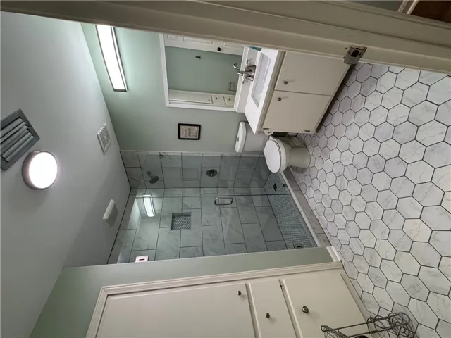 A well-appointed bathroom offers a modern walk-in shower and stylish hexagonal tile flooring.