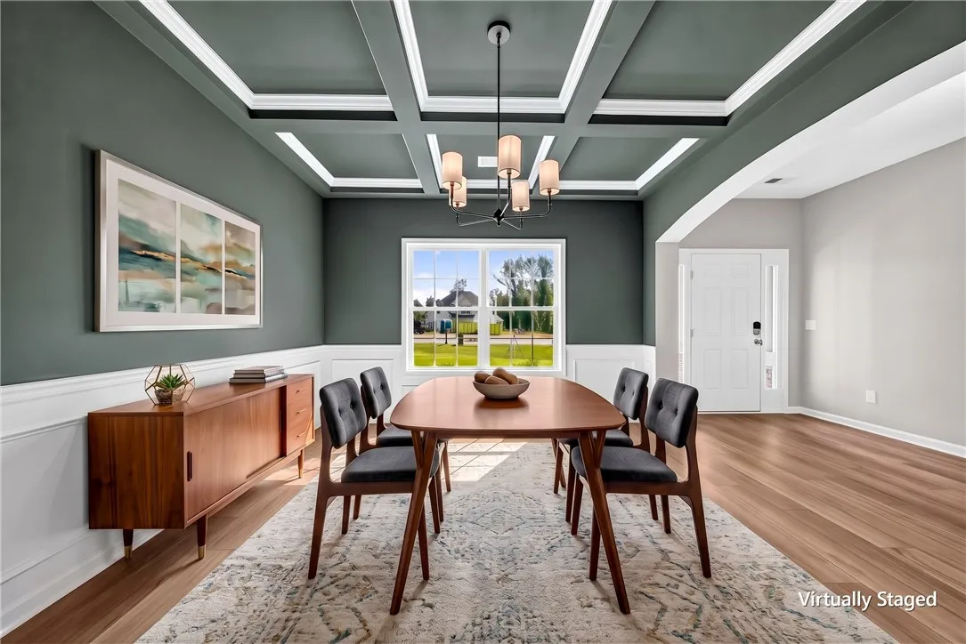 An elegant coffered ceiling and classic wainscoting define this formal dining space.