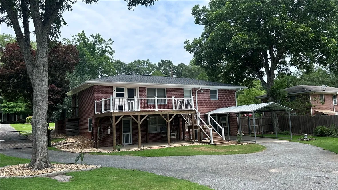 A well-maintained brick exterior residence with a spacious deck and covered parking invites easy living.