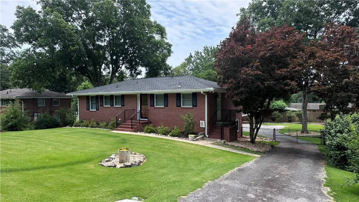 A classic brick exterior offers timeless appeal with mature landscaping and a private driveway.
