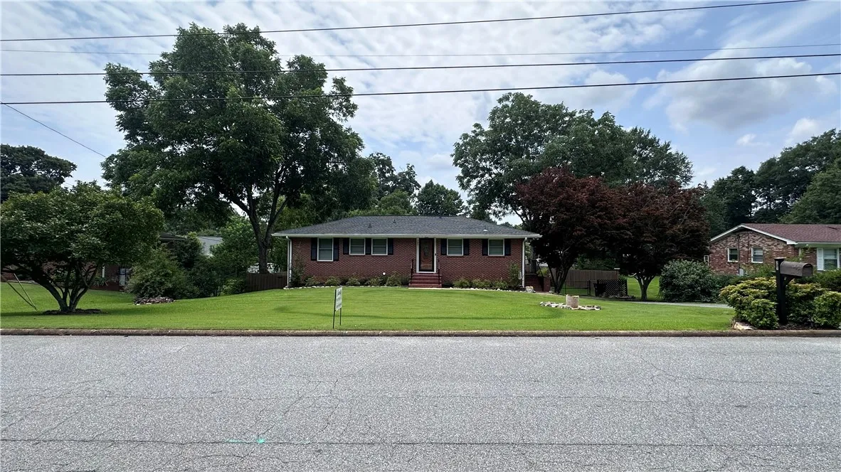 A classic brick exterior with dark shutters offers inviting curb appeal.
