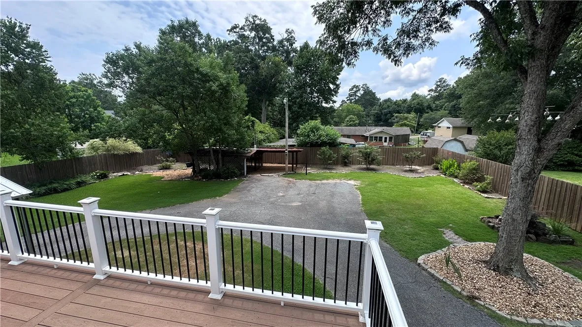 An inviting backyard oasis awaits, featuring a lush lawn and practical fenced perimeter.