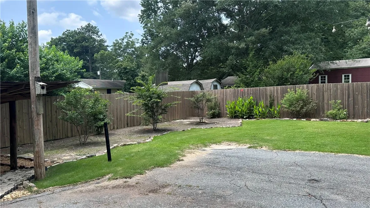 A neatly fenced private yard with vibrant green grass and carefully placed landscaping creates a serene outdoor haven.