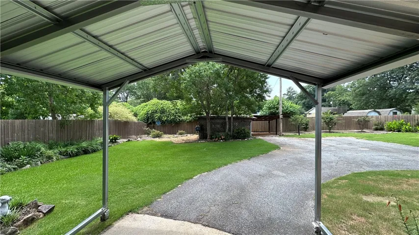 A well-maintained yard and paved driveway are sheltered by a spacious covered carport.