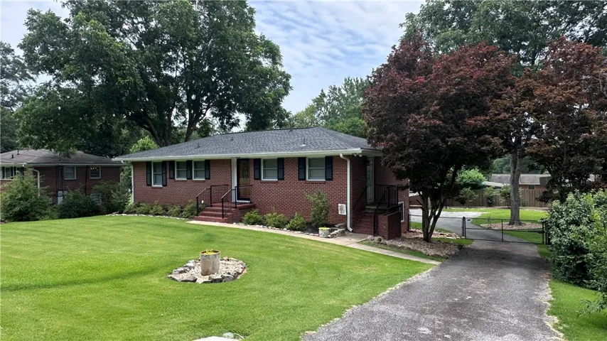 A classic brick exterior offers timeless appeal with mature landscaping and a private driveway.
