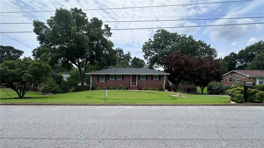 A classic brick exterior with dark shutters offers inviting curb appeal.