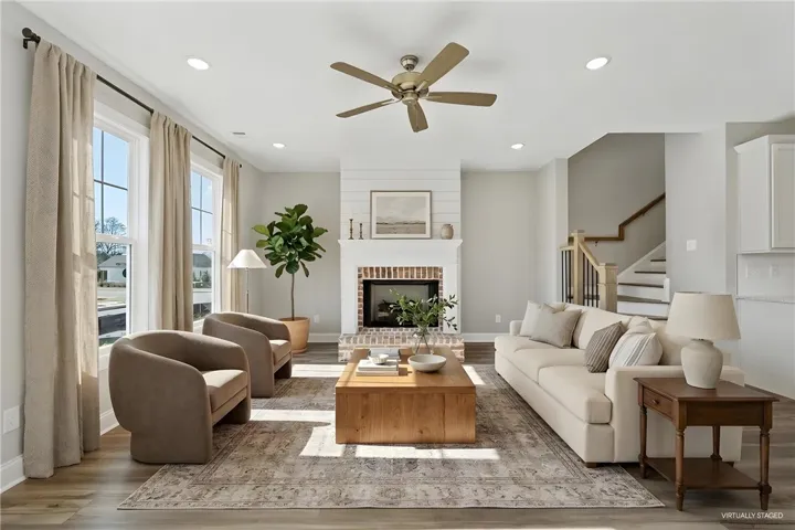 This bright living room offers comfortable gatherings around the fireplace.