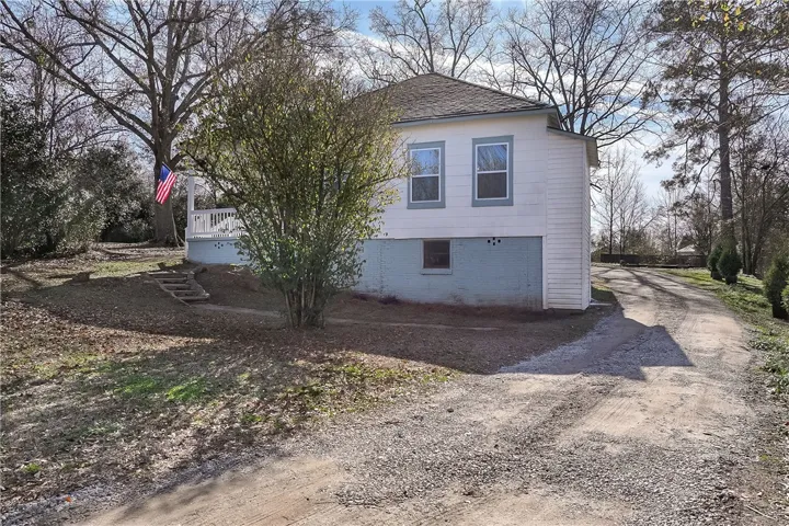 Driveway with new gravel leading to large parking pad at rear