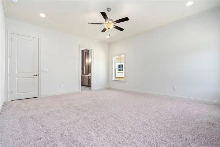 This spacious bedroom offers comfortable carpeting and a bright window for natural light.