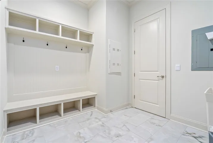 This functional mudroom offers organized storage with built-in shelving and convenient seating.