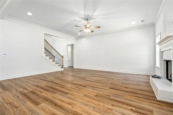 This expansive great room features warm wood flooring and a classic fireplace.