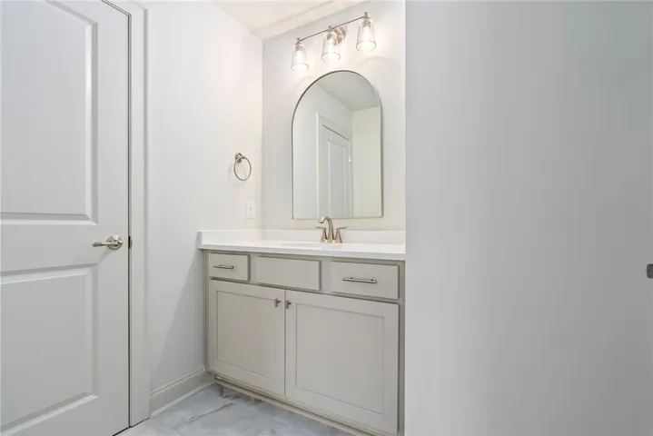 This clean bathroom vanity features a mirror and contemporary fixtures.