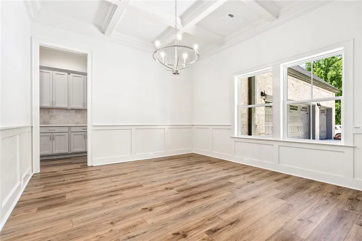 This bright and airy dining room features beautiful hardwood floors and coffered ceilings.