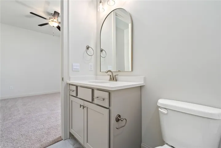 This bathroom features a contemporary vanity with a sleek countertop and an arched mirror.