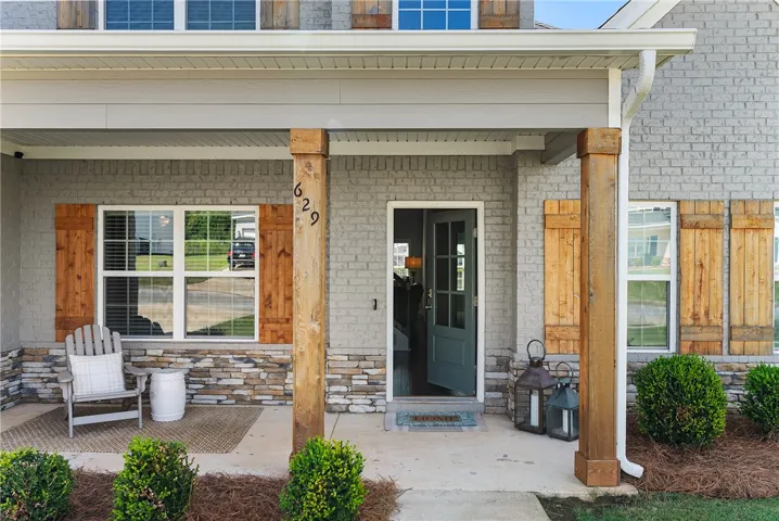 Welcome home to this charming front porch, featuring natural wood accents and a cozy seating area.