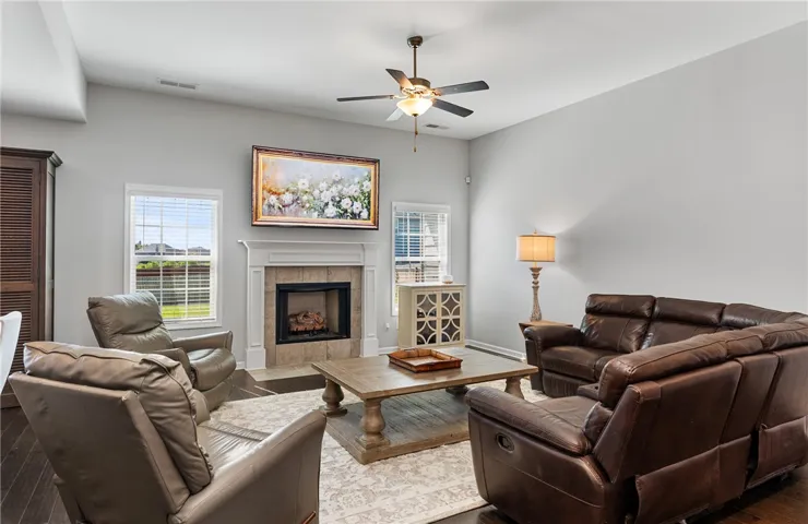 Relax and unwind in this inviting living area featuring a cozy gas fireplace, high ceilings, and rich hardwood flooring.
