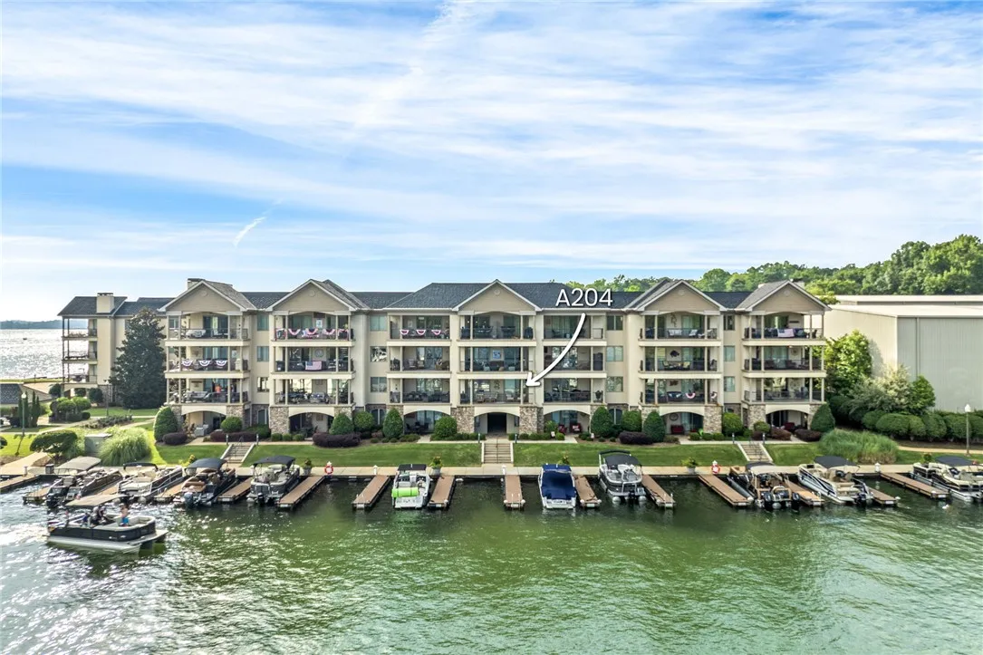 Boats dot the private dock of this impressive multi-story waterfront complex, offering stunning views and easy lake access.