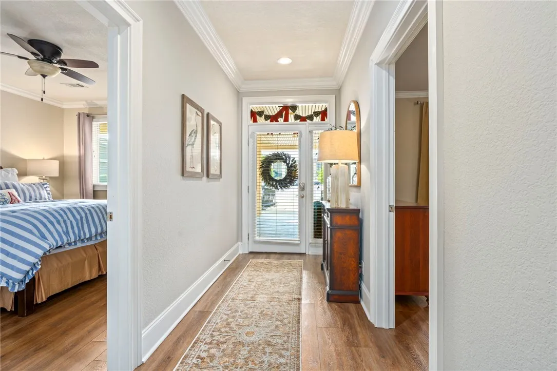 A welcoming entry corridor features lustrous wood flooring and elegant crown molding.