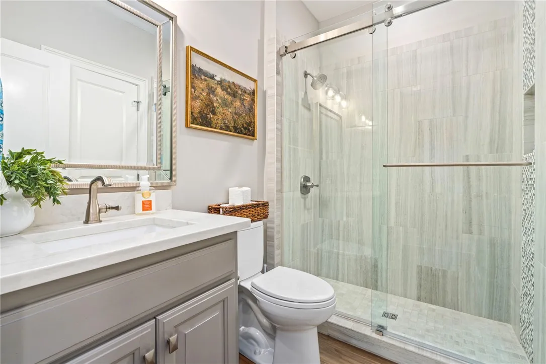 A well-appointed bathroom features a glass-enclosed shower and a vanity with a sleek countertop.