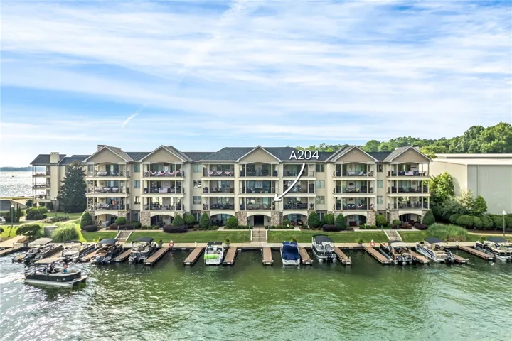 Boats dot the private dock of this impressive multi-story waterfront complex, offering stunning views and easy lake access.