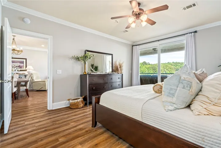 Hardwood flooring extends throughout this naturally illuminated bedroom with a private balcony offering verdant views.