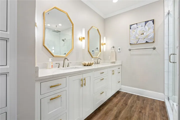 Dual vanities with modern fixtures offer convenience in this sleek, well-appointed primary bathroom.