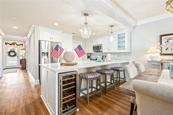 Chef's kitchen features stainless steel appliances, a generous island, and ample dining space.