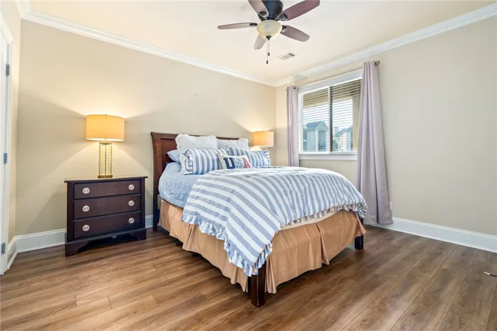 Relaxing private quarters feature warm wood-look flooring and crown molding.