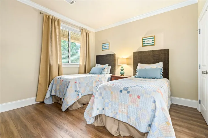 Hardwood floors and a sun-filled window make for a relaxing bedroom retreat.