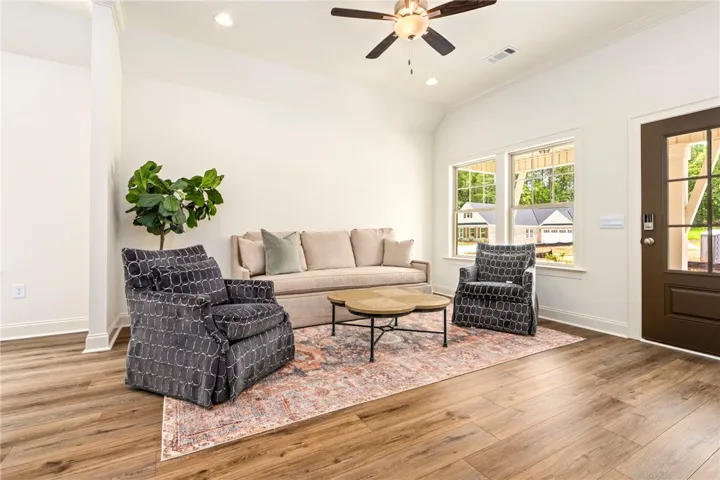 A welcoming living room featuring high ceilings and beautiful wood flooring, perfect for relaxation.