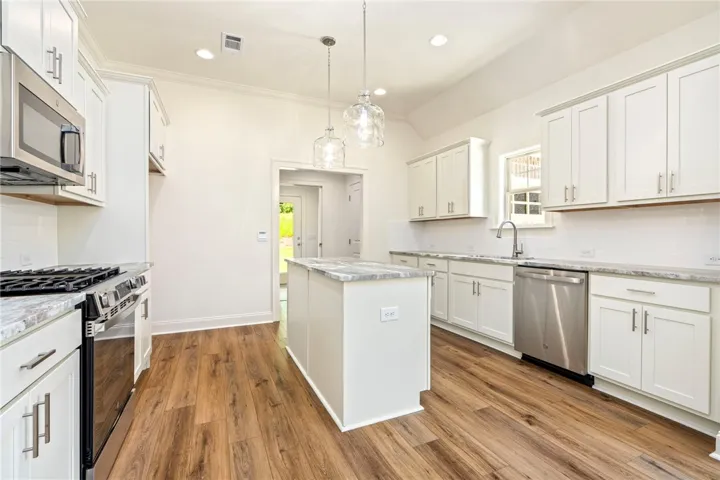Culinary delights await in this bright kitchen with an island, sleek appliances, and easy-care flooring.