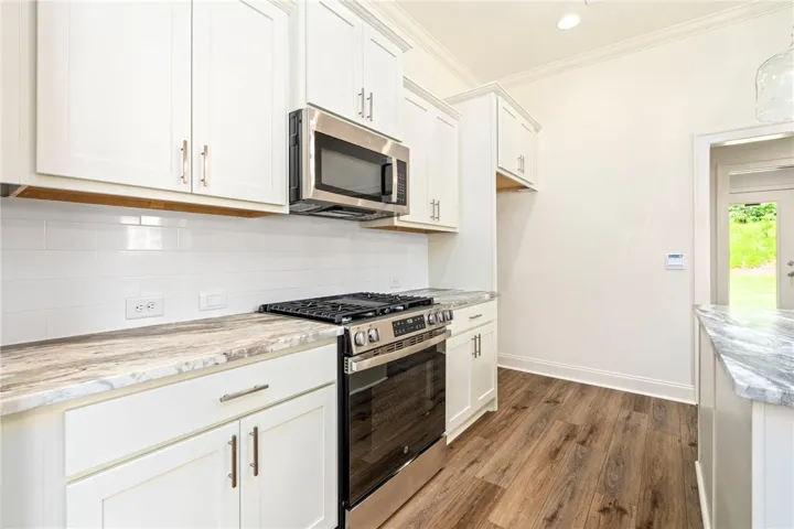A well-equipped kitchen showcases white cabinetry and modern stainless steel appliances.