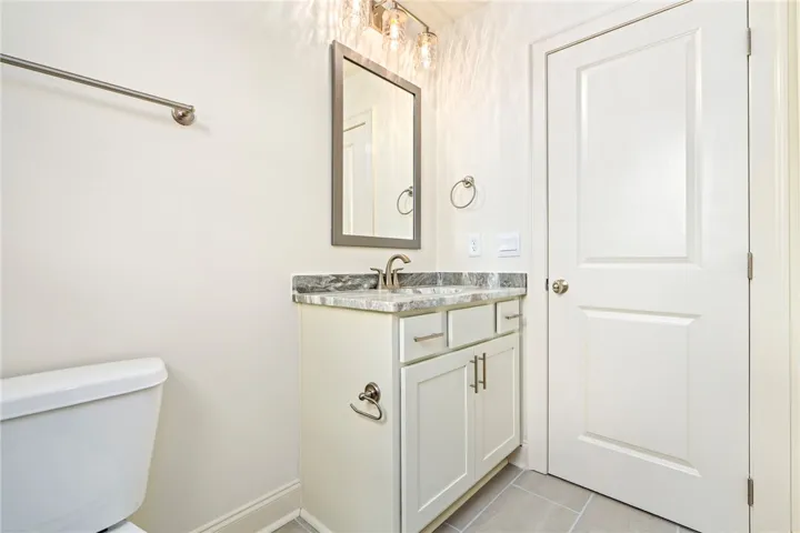 A well-appointed bath features a sleek vanity with ample storage and a modern light fixture.