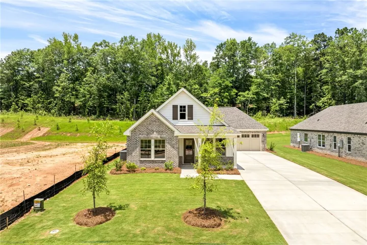 A charming single-story residence with a brick facade and ample green space awaits.