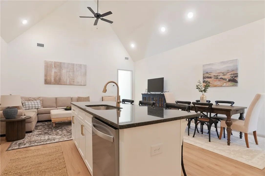 Granite counters and an open floorplan define this well-lit kitchen and living area.