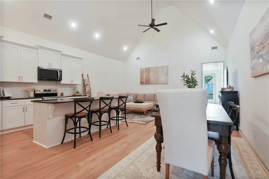An open concept living area features soaring vaulted ceilings and rich wood flooring.