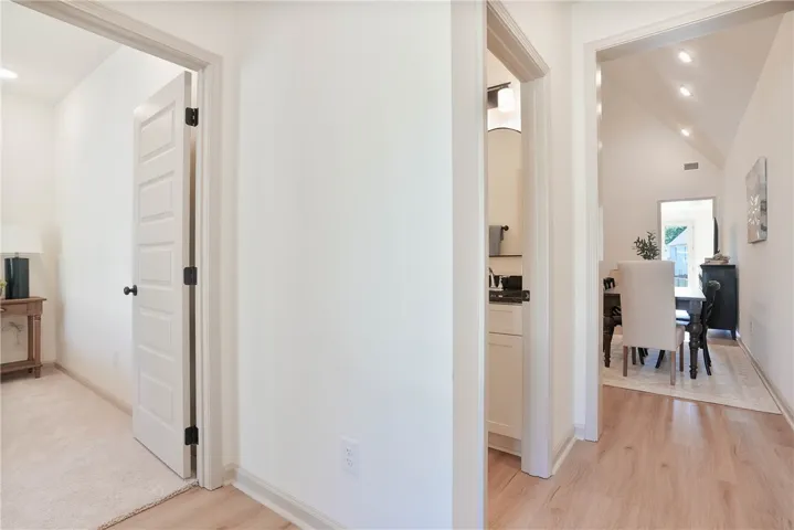 A well-lit corridor with various doorways leads to functional and inviting spaces within.