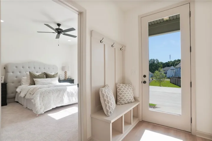 A welcoming entryway with built-in storage leads to a serene primary bedroom.