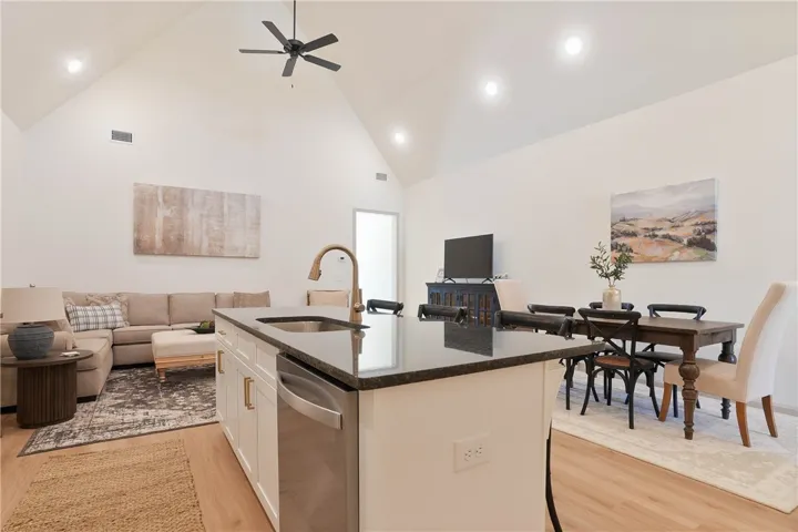 Granite counters and an open floorplan define this well-lit kitchen and living area.