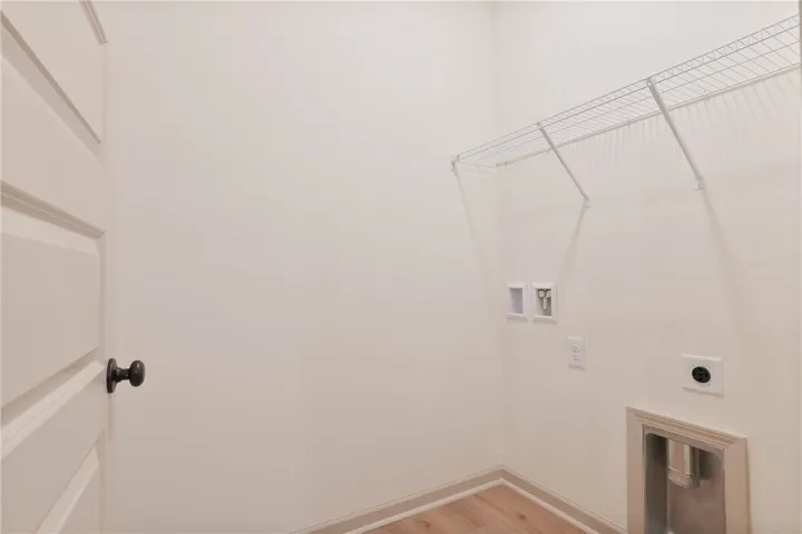 A dedicated laundry room with hookups and convenient storage shelving.
