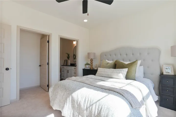 A tranquil primary bedroom with soft, inviting textures offers direct access to a private, well-appointed bathroom.