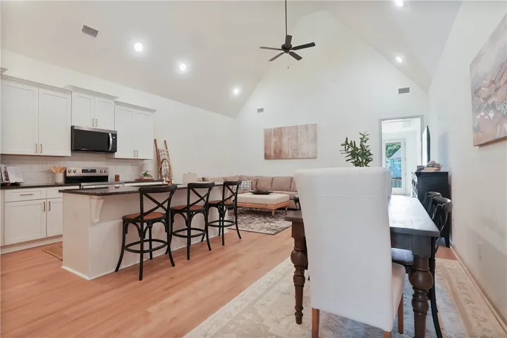 An open concept living area features soaring vaulted ceilings and rich wood flooring.