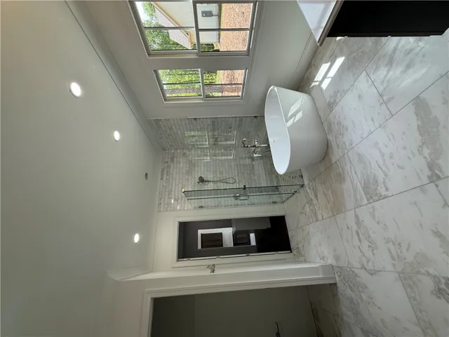 This spacious bathroom offers a serene retreat with elegant fixtures and natural light.