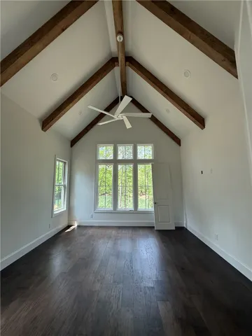 This airy room features vaulted ceilings, rich hardwood flooring, and ample natural light.