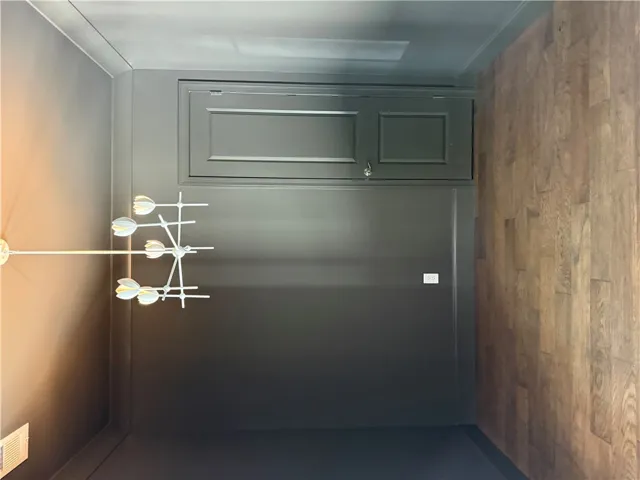 This refined space features rich wood flooring and a stylish lighting fixture, creating an inviting ambiance.