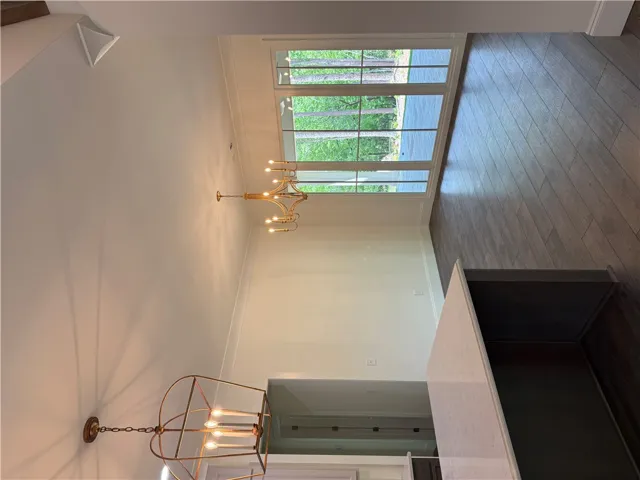 This airy space showcases natural light, sleek flooring, and distinctive lighting fixtures.