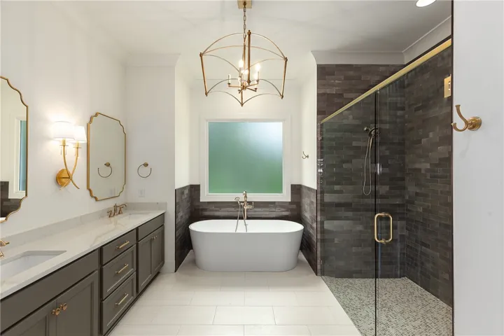 Luxurious bathroom with dual vanities, a freestanding tub, and a spacious glass-enclosed shower.